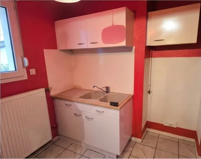 Cuisine avant rénovation, avec murs rouges et anciens meubles