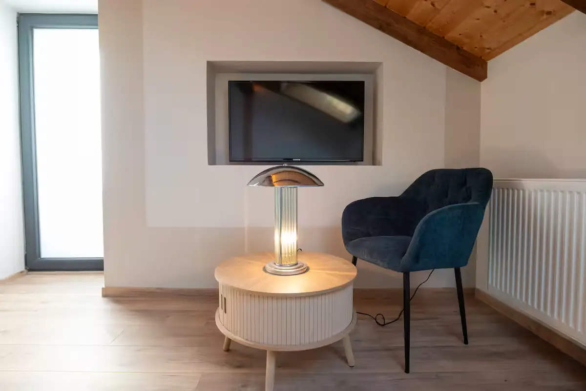 Intérieur aménagé avec coin salon, meuble rond et plafond en bois