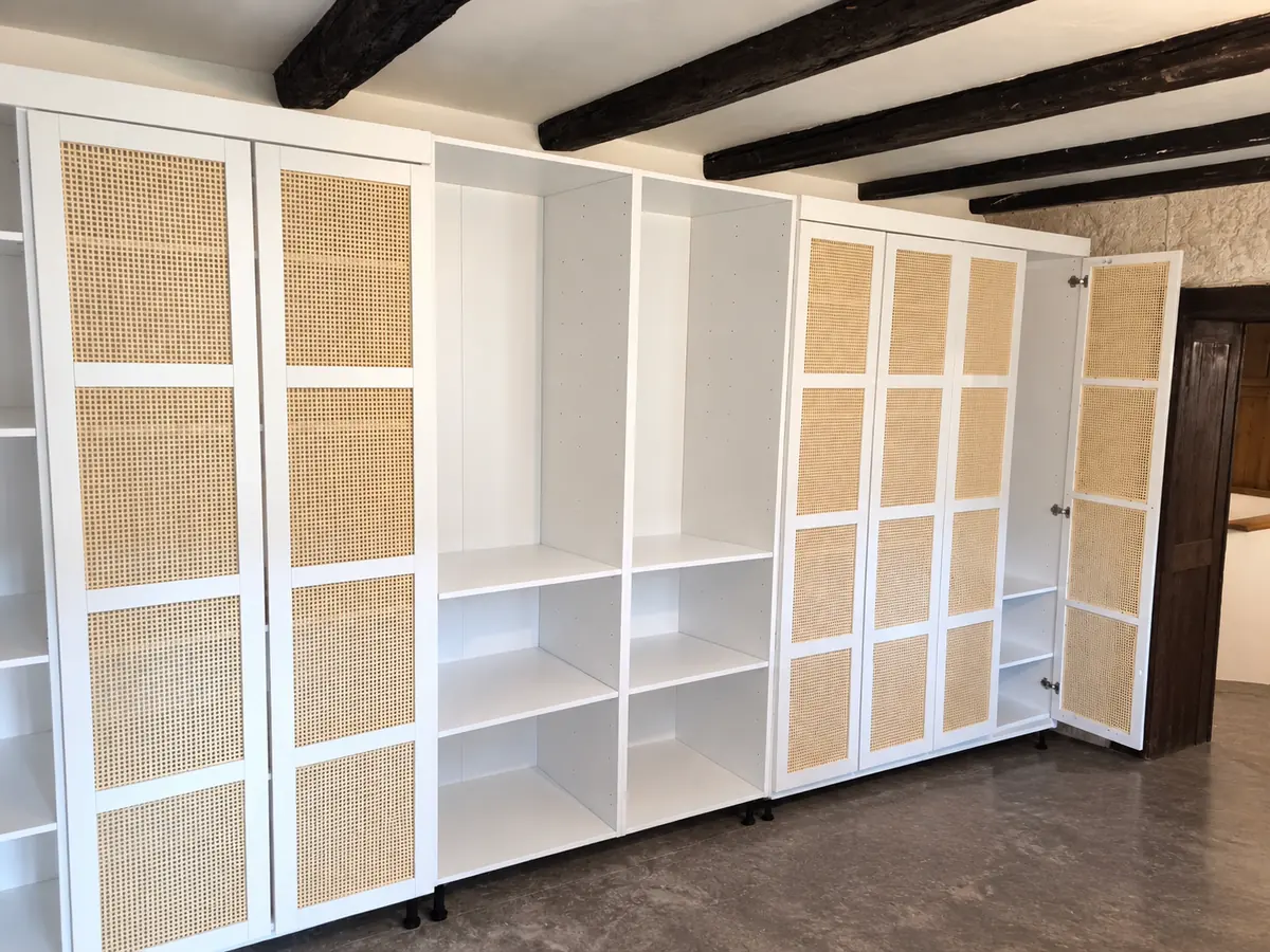 Grand placard sur mesure blanc avec portes en cannage sous des poutres apparentes